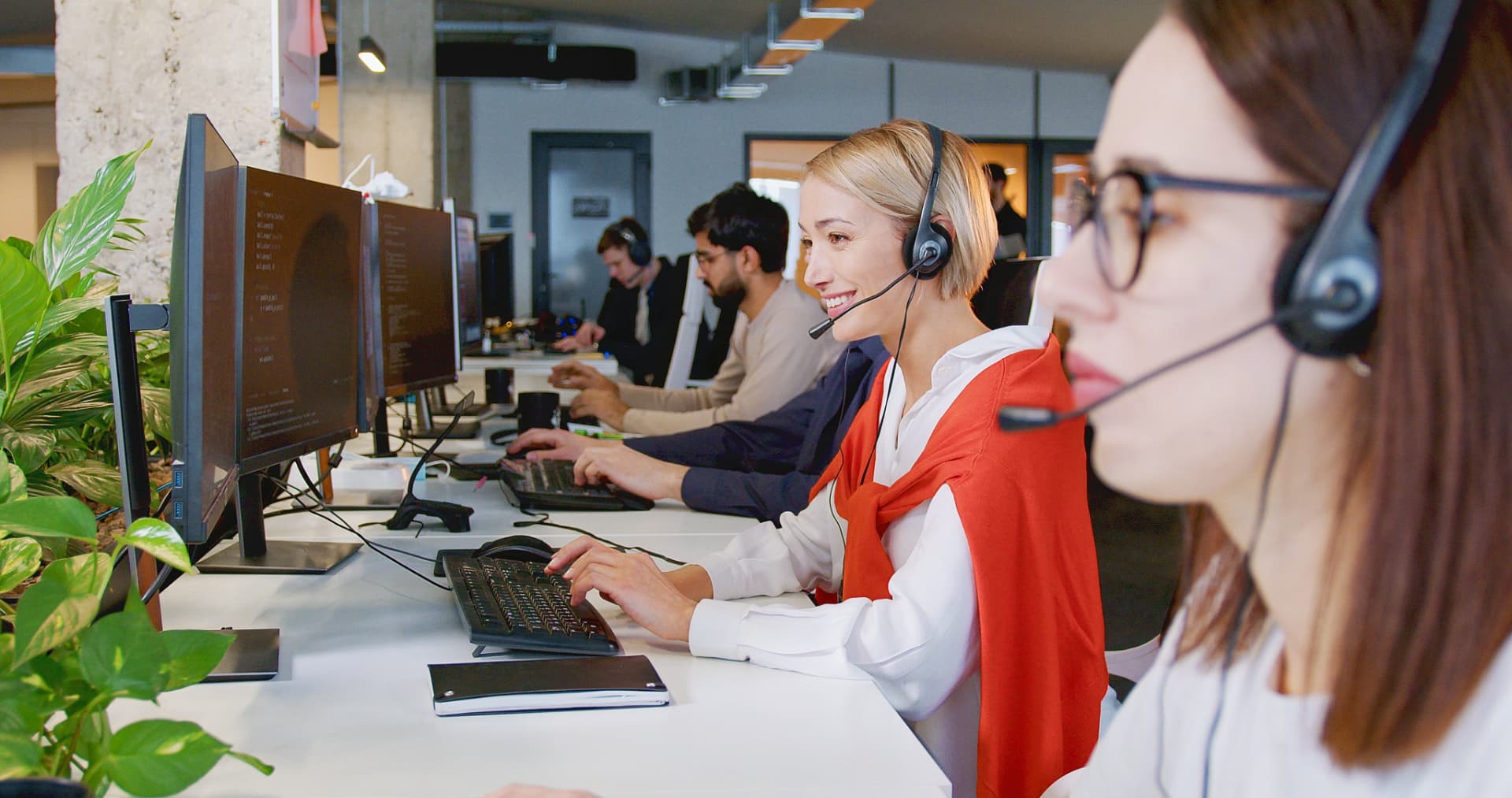 Customer service agent with a headset assisting a customer in a bright office