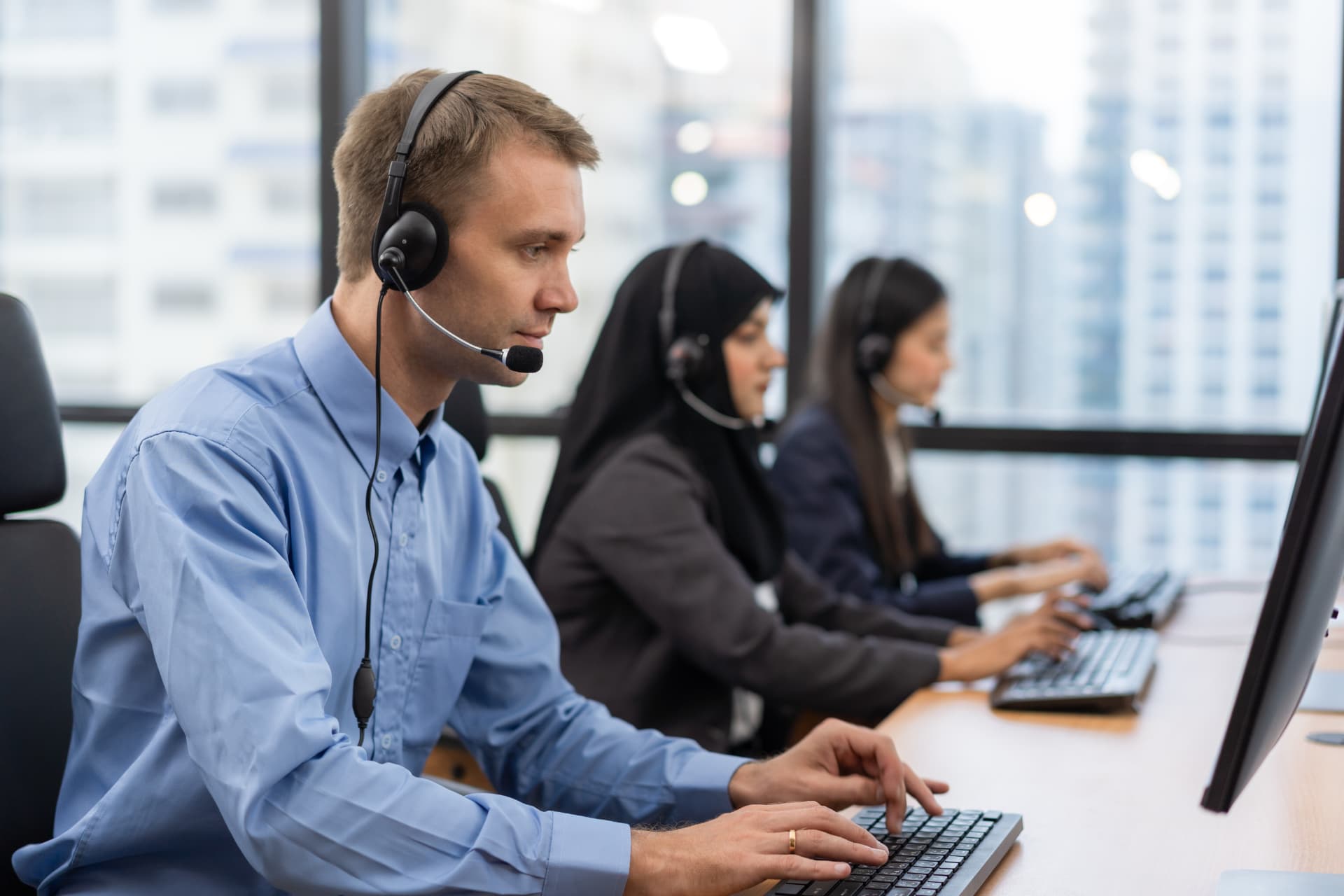 Sales representative with a headset on a business call in a modern office